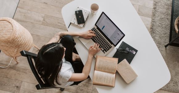 Effective Job Search - Young lady typing on keyboard of laptop in living room