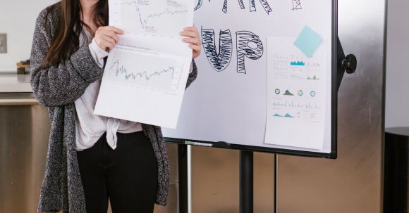 Elevator Pitch Tips - Woman in Gray Coat Holding White Printer Paper