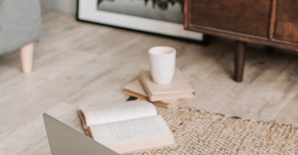 Job Search Resilience - Laptop and books on floor carpet