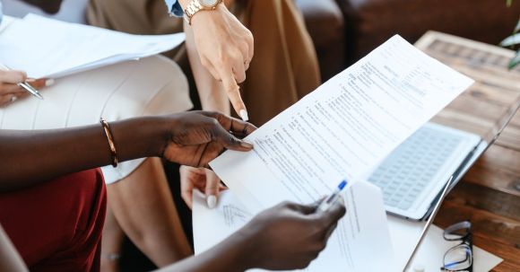 Company Research - Multiethnic businesswomen checking information in documents